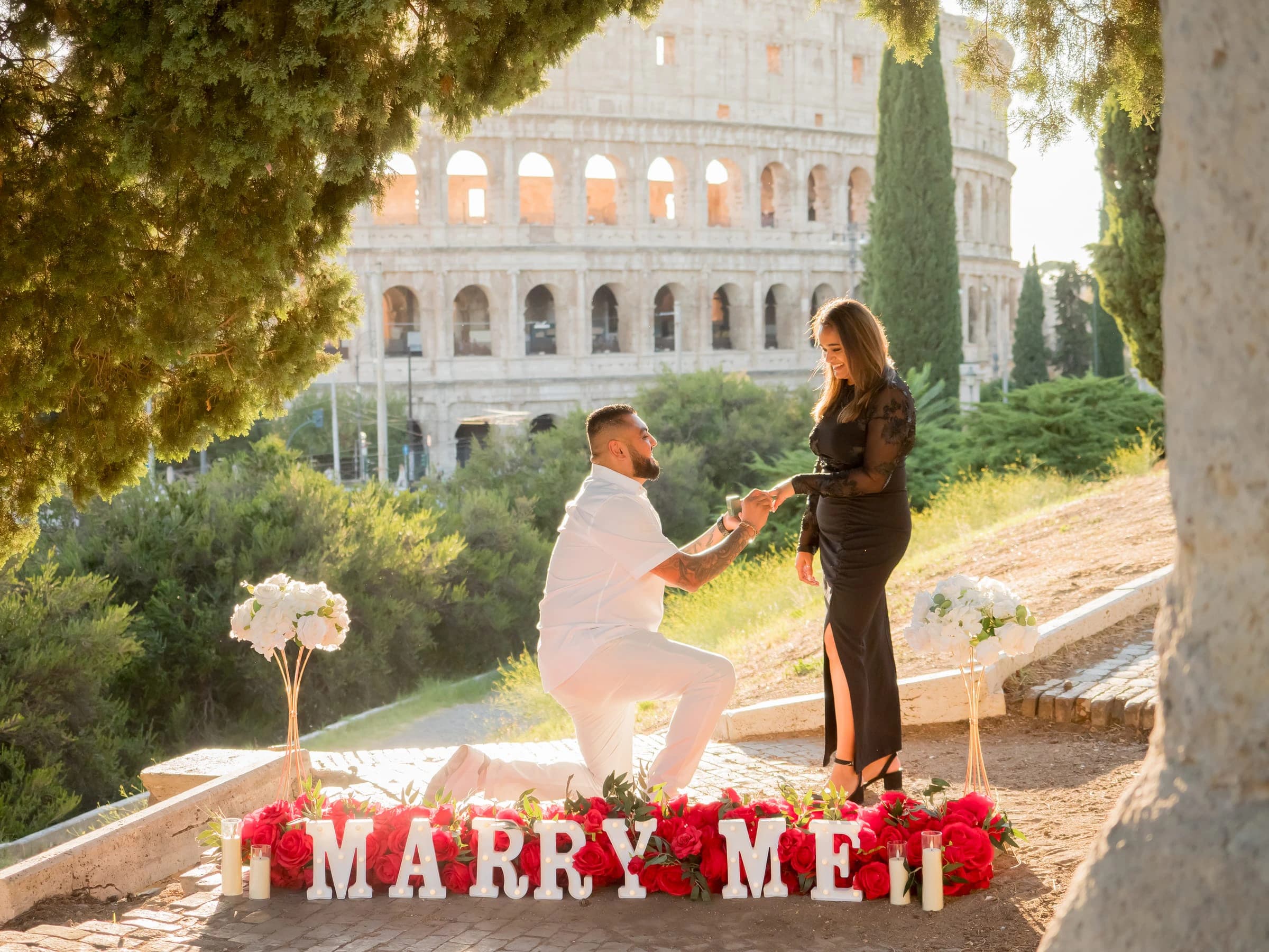A proposal behind Marry Me letters with the Colosseum in the background